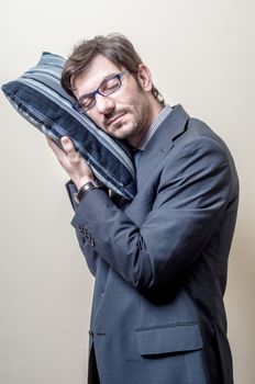 businessman sleeping on pillow on gray background