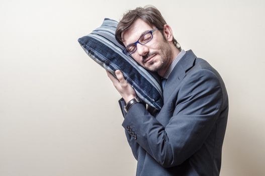 businessman sleeping on pillow on gray background