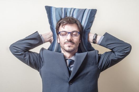 businessman sleeping on pillow on gray background