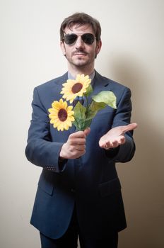 elegant man with daisies on gray background