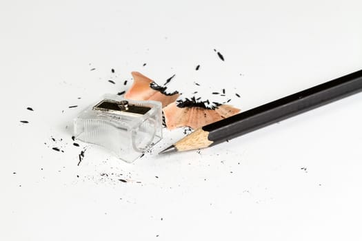 Pencil and sharpening shavings on dirt white background