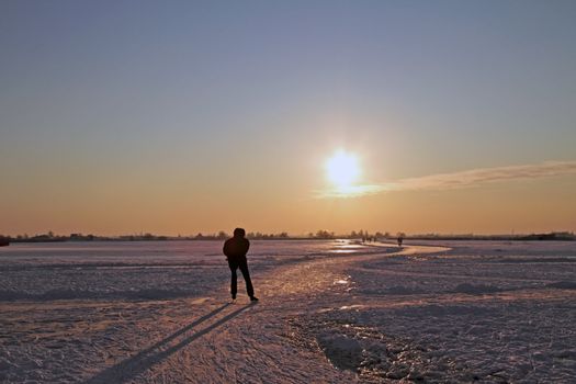 Ice skating in the countryside from the Netherlands at sunset
