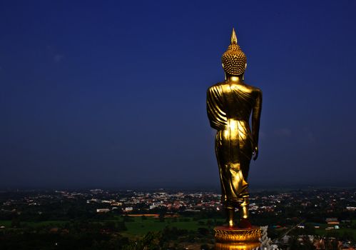 Black golden buddha statue against blue sky in thai temple, Thailand