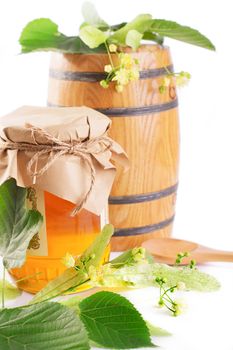 Linden honey jar and barrel with flowers isolated on white