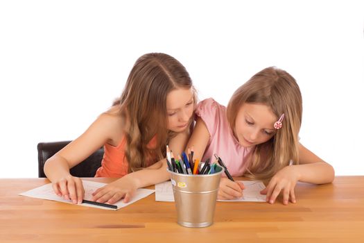 Big sister tries to copy the drawing of her little sister. Isolated on a white background.