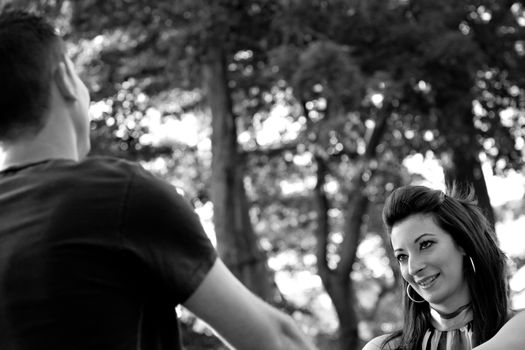 A happy young couple in their mid 20s smiling in black and white.