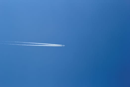 aircraft in a clear blue sky with condensation trail