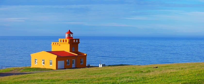 North Iceland Sea Landscape with Orange Lighthouse and Blue Sky. Panorama