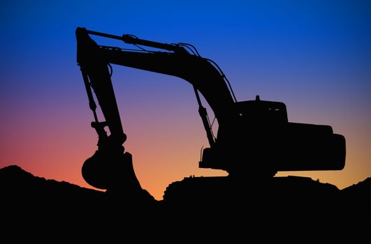 a big bulldozer working on a sunset