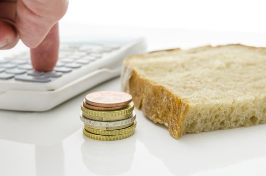 Piece of bread with male hand calculating basic living expenses.