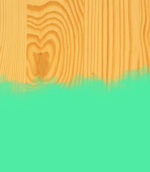 Green stroke of the paint brush on wooden background 