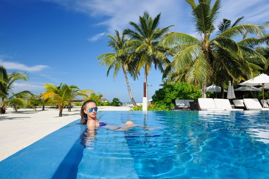 Woman in hat relaxing at the pool 