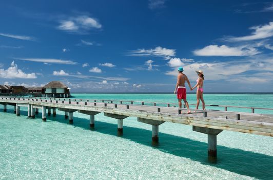 Couple on a tropical beach jetty at Maldives