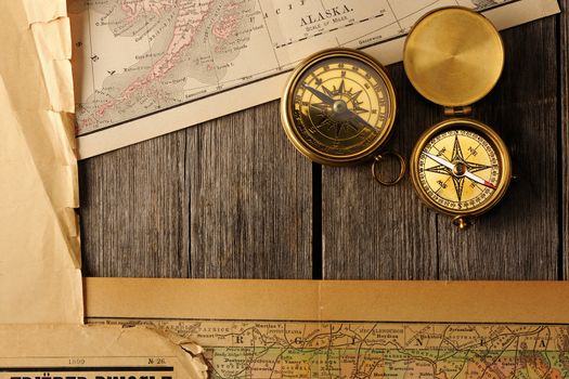 Antique brass compasses over old map