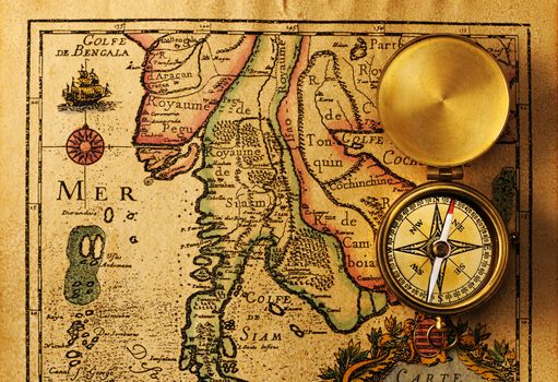 Antique brass compass over old map