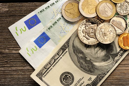 US and euro currency over wooden background