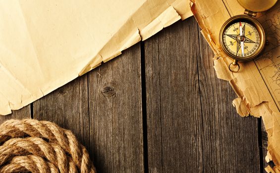 Antique brass compass and rope over old map