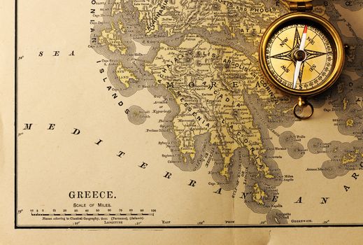 Antique brass compass over old XIX century map
