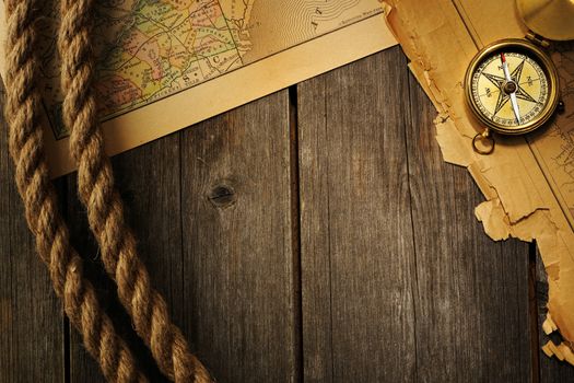 Antique brass compass and rope over old map