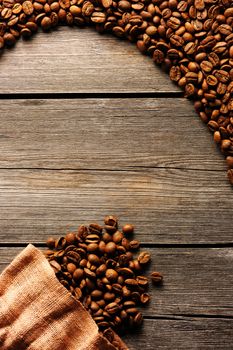 Coffee beans and bag over wooden background