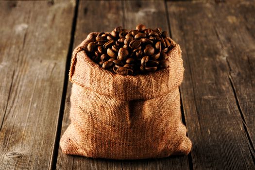 Coffee beans in bag on wooden table