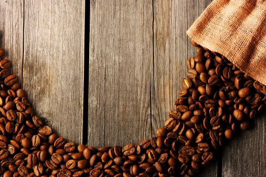 Coffee beans and bag over wooden background