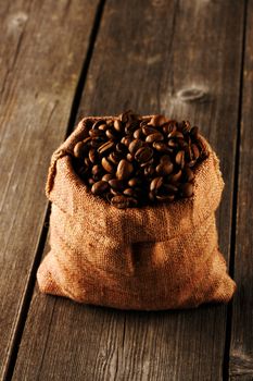 Coffee beans in bag on wooden table