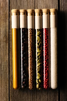 Spices in beakers on wooden background