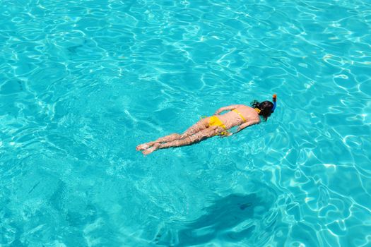 Woman snorkeling in crystal clear turquoise water at tropical beach