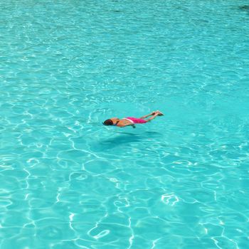 Man snorkeling in crystal clear turquoise water at tropical beach