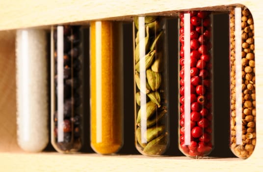 Spices in beakers against dark background