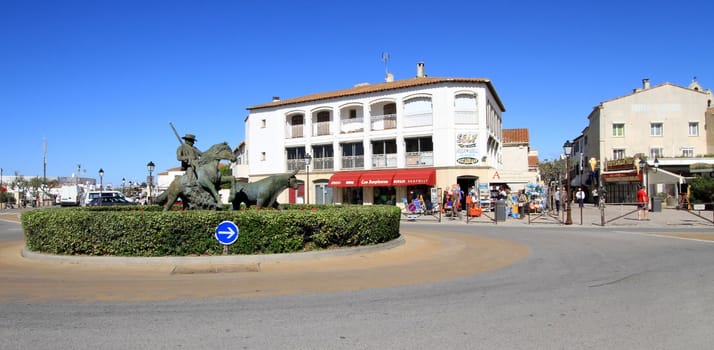 Statue of a typical guardian and bull statue at a roundabout in the center of Saintes-Maries-de-la-mer village, Camargue, France