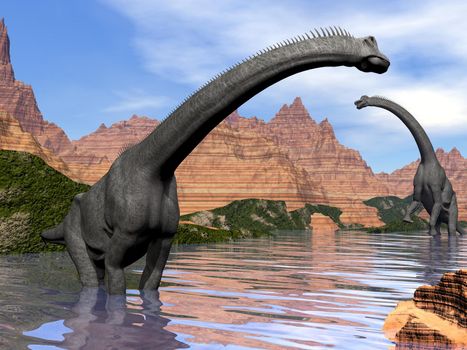 Two brachiosaurus dinosaurs in water next to red rock mountains by beautiful day