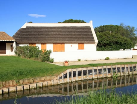 Typical guardian house next to a small water canal by beautiful weather, Camargue, France