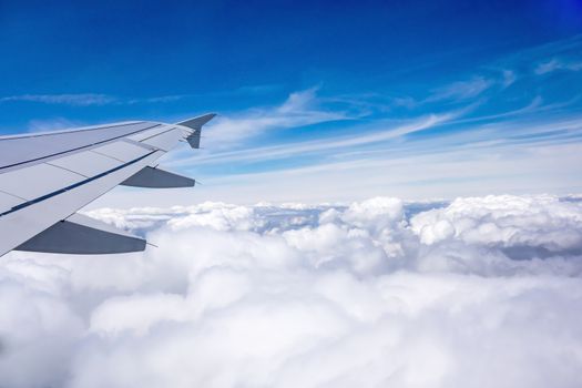 Wing of an airplane over the clouds during flight