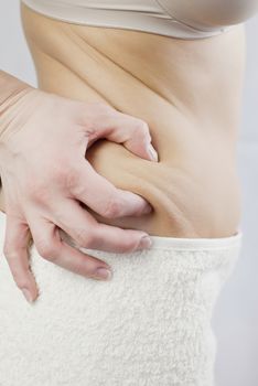 young woman holding her skin for cellulite check