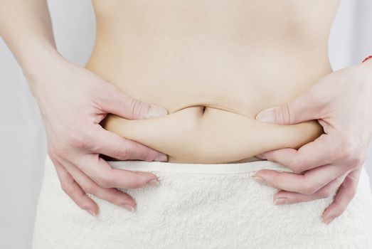 young woman holding her skin for cellulite check