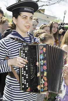  Moscow, Russia - May 9, 2013: Young girl in uniform decorated playing accordion festivities devoted to 68th anniversary of Victory Day.