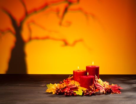 Candles in scary Halloween landscape with dry tree
