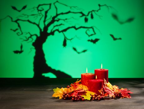 Candles in scary Halloween landscape with dry tree