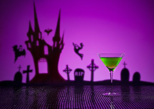 Green Martini in Halloween setting with witch and haunted house