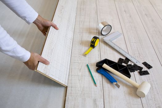  Worker laying a floor with laminated flooring boards 