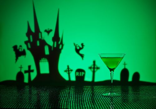 Green Martini in Halloween setting with a haunted house