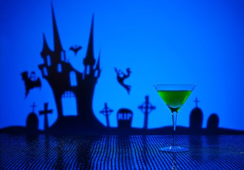 Green Martini in Halloween setting with witch and haunted house
