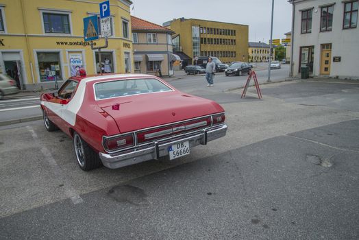 The image is shot at a fish-market in Halden, Norway where there every Wednesday during the summer months are held classic American car show.