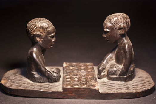 African wooden figures depicting a game of checkers