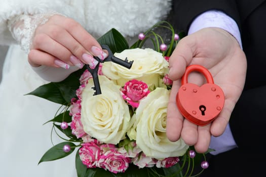 couple's hands holding wedding lock and keys