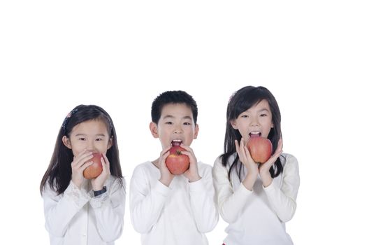 Three cute children eating an apples