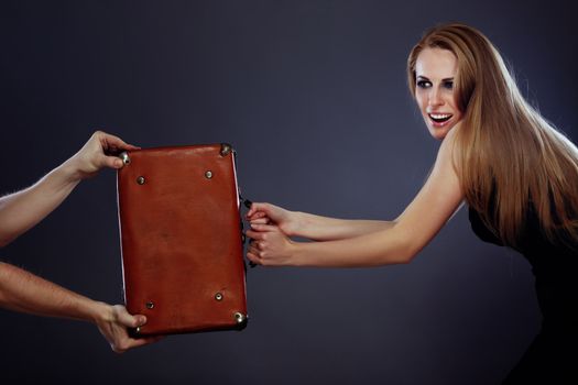 Businesswoman holding bag with money and competiting with hands of somebody