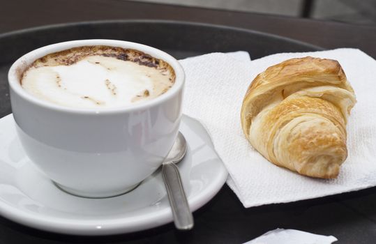 croissant with cappuccino inside tray